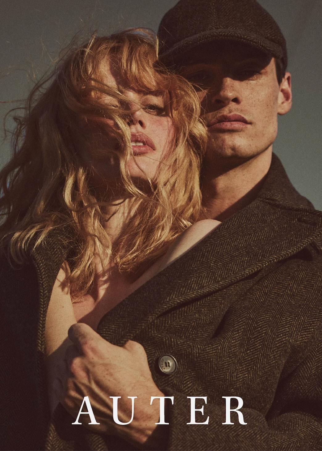 Two people embracing with a neutral background and 'AUTER' branding.