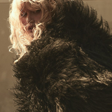 Model wearing a long curly-haired shearling fur jacket.